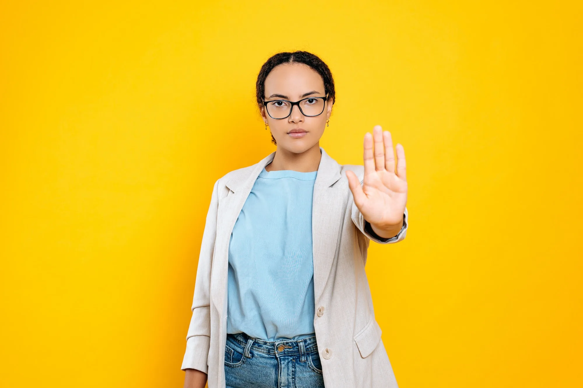 serious concerned resolute young brunette hispanic or brazilian woman showing stop gesture